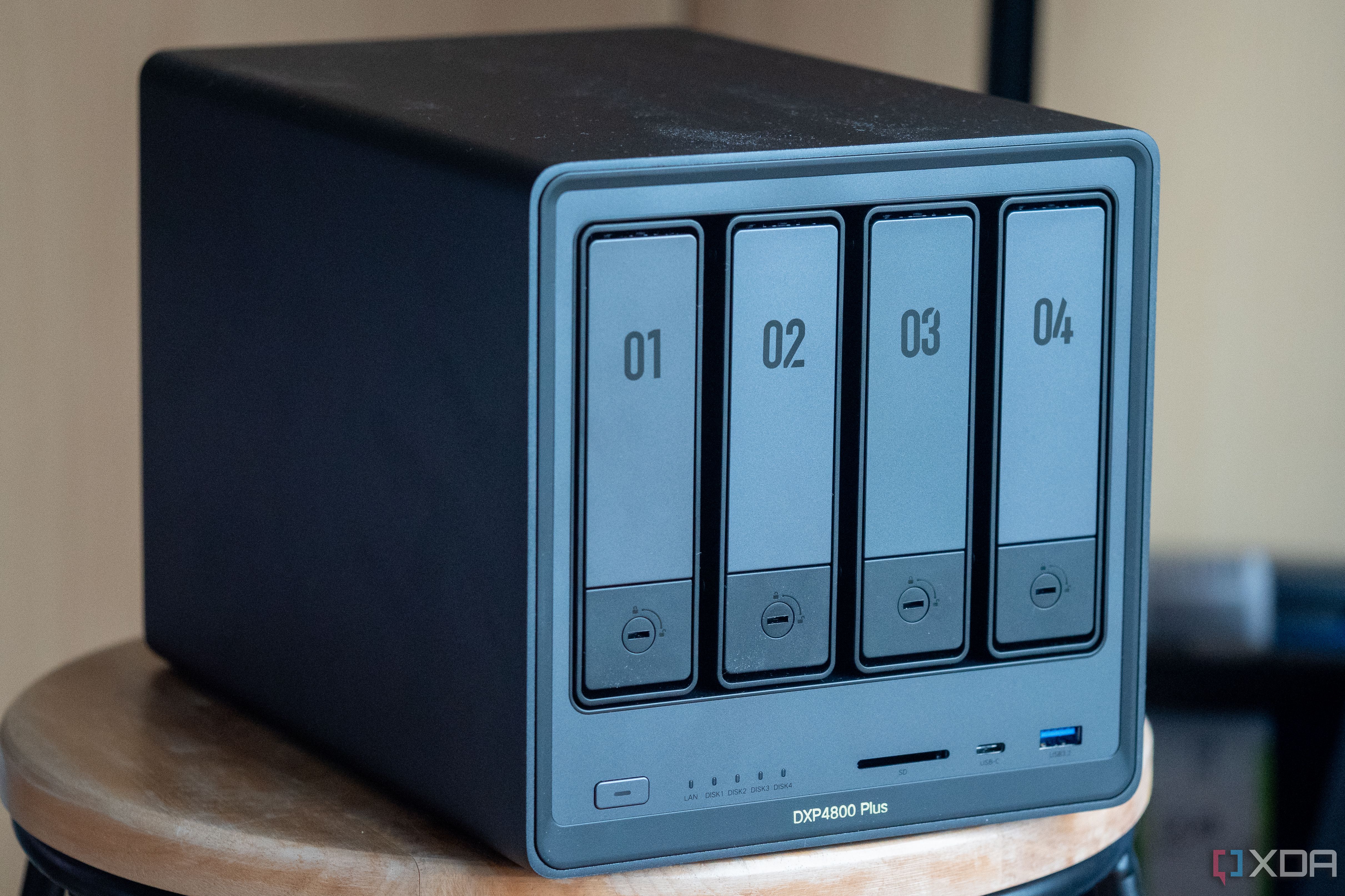 Ugreen NAS on a table, showing the four drive bays and front ports